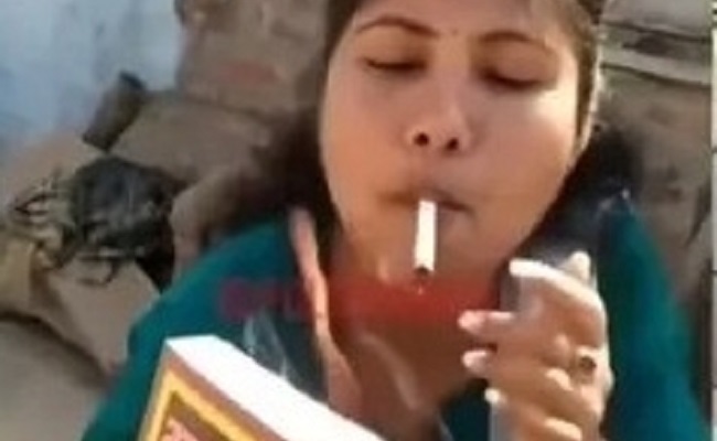 Woman sets Manusmriti on fire, lights cigarette with it